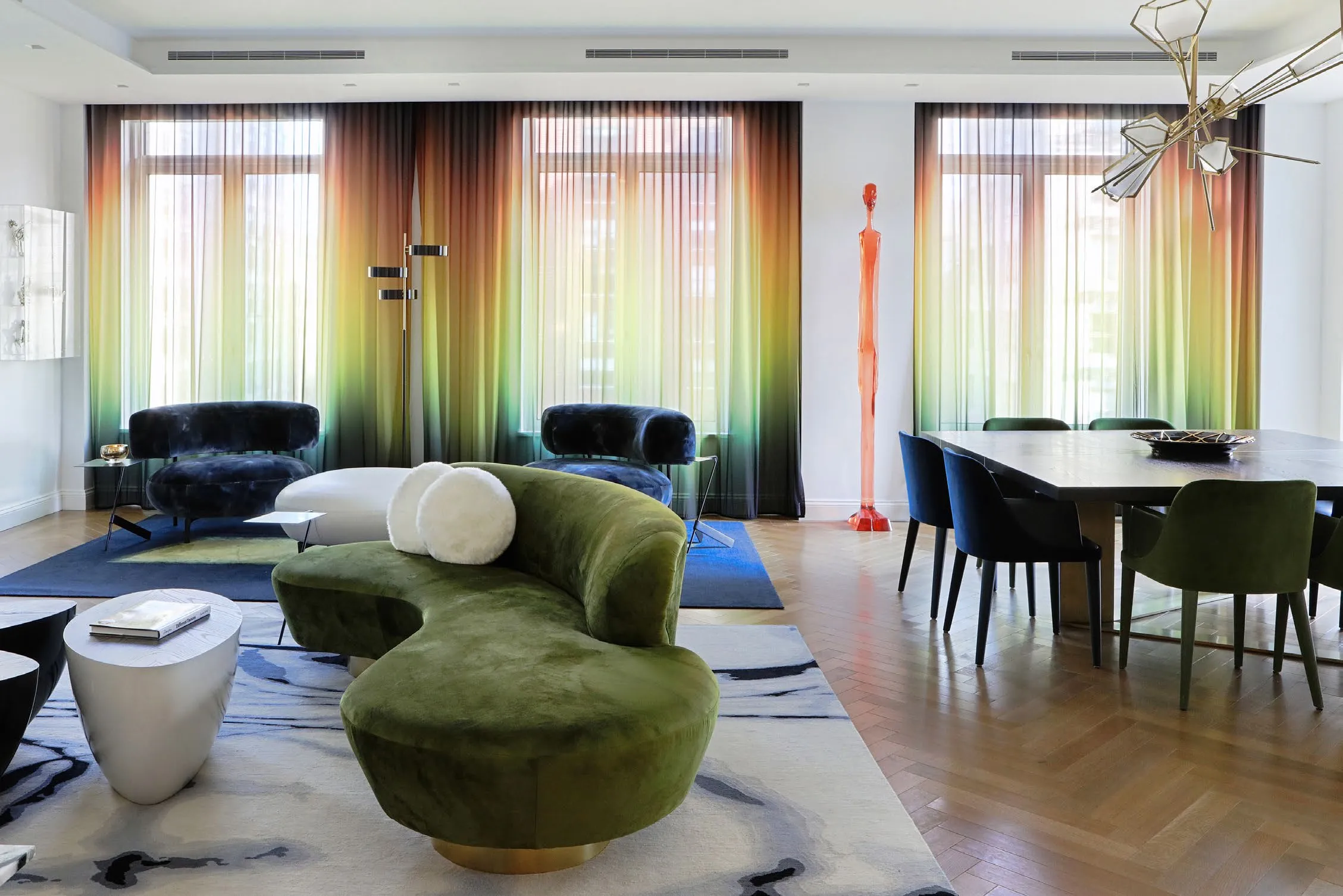 Great room of K Residence with a green velvet sofa and yellow accent pillows
