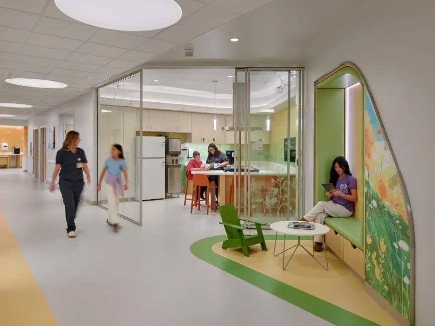 Atrium of the children's hospital with curved openings and a soft green play area