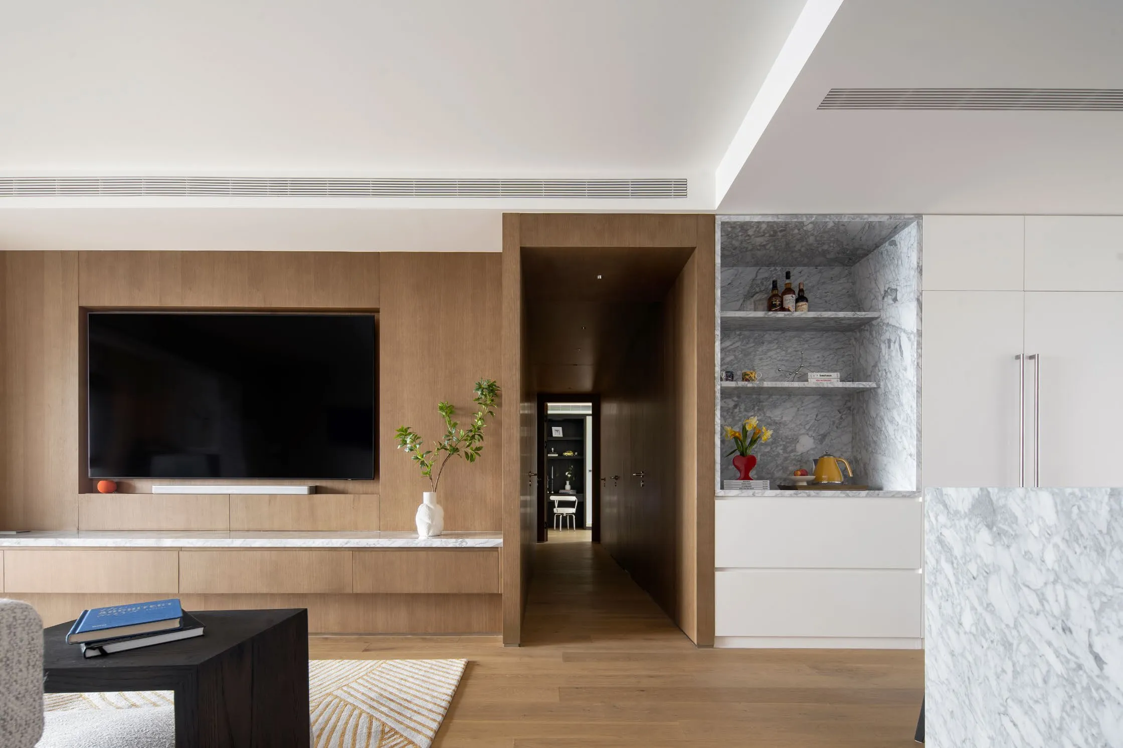 A great room in warm neutrals — pale marble, white walls and walnut cabinetry