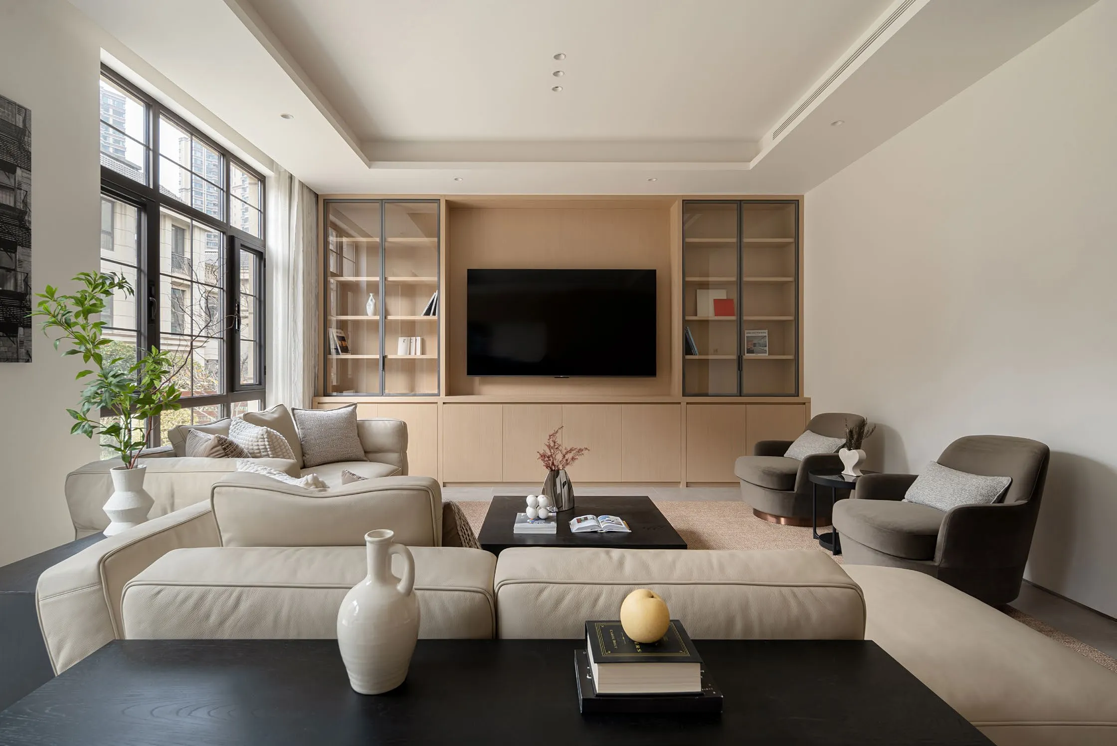Great room of Z Residence: a cream sofa and dark accents under soft window light